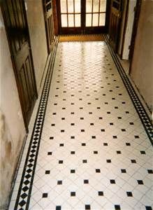 an empty hallway with black and white tile