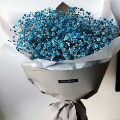 a bouquet of blue flowers wrapped in paper