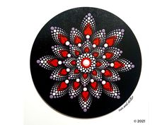 a black plate with red and white designs on it's surface is featured in this image