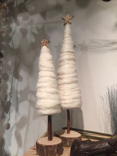 two small white christmas trees on wooden logs