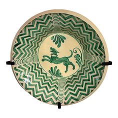 a green and white bowl with a dog on it's side, in the shape of a zigzag pattern