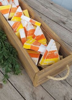 a wooden box filled with orange and yellow candy