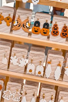 wooden earrings with carved pumpkins and ghost faces on them for sale at a market