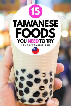 someone holding up a drink with the words 15 japanese foods you need to try