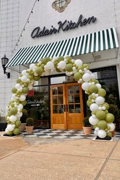 the entrance to an italian kitchen with white and green balloons