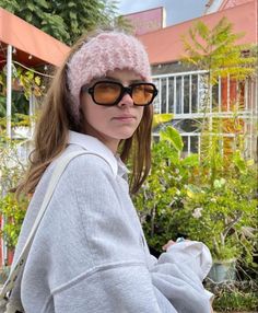 a woman wearing sunglasses and a pink hat