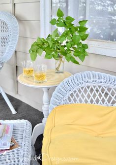 two wicker chairs and a small table with drinks on it