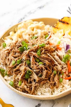 a bowl filled with rice, meat and veggies on top of a table