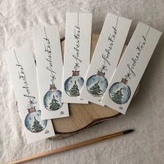 six handmade christmas ornaments with writing on them next to a pencil and paper towel