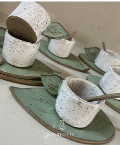 four ceramic cups and saucers with leaves on them