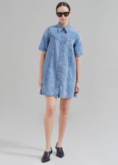 Color: Mid Blue Vintage Midweight denim Relaxed fit A-line silhouette Mini length Pointed collar Short sleeves Side seam hip pockets Ganni logo blue metal buttons Front button closure Unlined 100% Organic Cotton Cold Machine Wash By GANNI. Made in Turkey Blue Denim Dress With Buttoned Pockets, Fitted Denim Shirt Dress With Buttons, Fitted Denim Shirt Dress With Button Closure, A-line Denim Dress With Pockets, Denim Blue Relaxed Fit Denim Dress With Button Closure, Relaxed Fit Denim Blue Denim Dress With Button Closure, Denim Blue Shirt Dress With Buttons, Relaxed Fit Denim Shirt Dress With Short Sleeves, Fitted Medium Wash Shirt Dress With Pockets