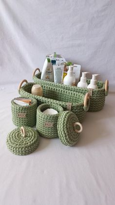 a green crocheted basket filled with lots of items on top of a white surface