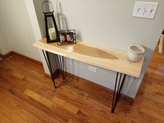 a wooden table with hairpin legs and a photo on the shelf next to it