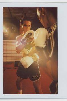 a man standing next to another man wearing boxing gloves