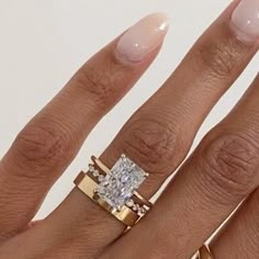 a woman's hand with two gold rings and a diamond ring on her finger