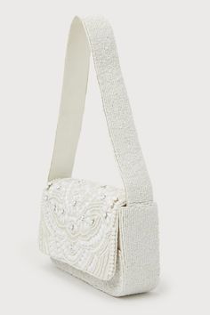 Make your 'fit even more sensational with the addition of the Lulus Glamorous Shine Ivory Beaded Shoulder Bag! Gleaming white beads (in varying shapes and sizes) create a multitude of designs across this woven fabric shoulder bag that boasts a rectangular silhouette that a flat bottom design. Lift the hidden magnetic closure at the front flap to reveal a roomy, lined interior with a sidewall pocket. A shiny gold chain strap included if you're in the mood to style this bag as a crossbody! Lined. White Embellished Rectangular Shoulder Bag, White Embellished Bag For Everyday Use, Embellished Cream Evening Bag, Embellished Cream Bags For Events, Chic Beaded Cream Shoulder Bag, Chic Beaded Cream Bag, Chic Cream Beaded Shoulder Bag, Chic Cream Beaded Bags, Chic Cream Beaded Bag