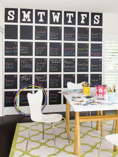 a room with a table, chairs and a chalkboard wall in the background that says smtwits