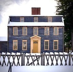 a blue house with white snow on the ground