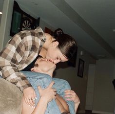 a man and woman kissing each other while sitting on a couch