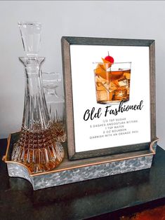 an old fashioned poster is sitting on a table next to glasses and a decanter