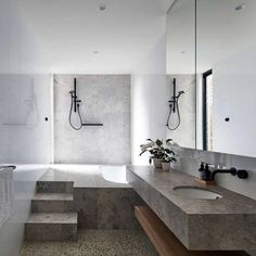 a bathroom with two sinks, a bathtub and a shower head mounted to the wall