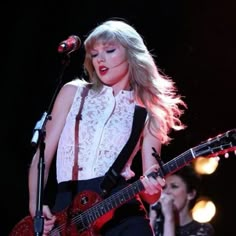 taylor swift performing with her guitar at the concert