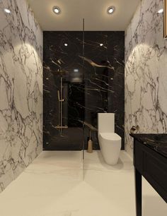 a bathroom with black and white marble walls, flooring and lights on the ceiling