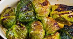 cooked brussel sprouts in a white bowl on a wooden table top