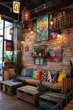 a living room filled with lots of furniture next to a brick wall covered in pictures