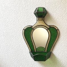 a green and white mirror mounted to the side of a wall