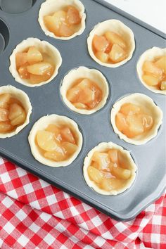 an uncooked muffin tin filled with mini pies covered in caramel sauce