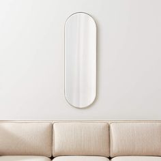 a living room with a couch and mirror on the wall