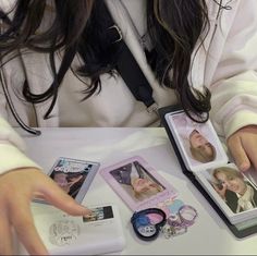 a woman sitting at a table with some pictures and jewelry on it's lap