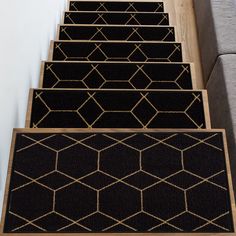 three black and gold rugs are on the stairs