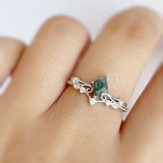 a woman's hand with a green ring on it