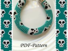 the beaded bracelet is decorated with black and white skulls on turquoise green fabric, along with a metal bar