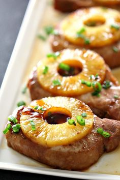 pineapple and pork chops on a white platter with garnishes