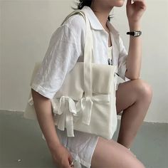 a woman sitting on top of a white toilet holding a cell phone to her ear