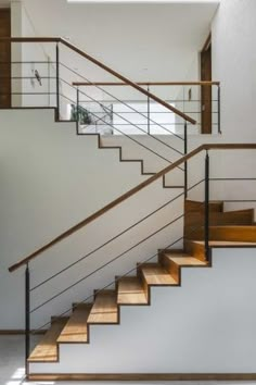 an open staircase with wooden handrails and white walls