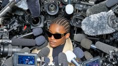 a woman surrounded by microphones and cameras