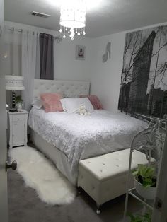 a bedroom with a white bed and chandelier hanging from it's ceiling