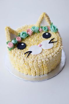 a cake decorated like a cat with flowers on top