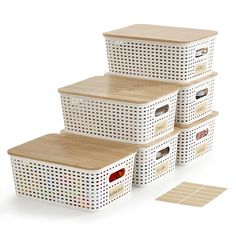 four white baskets stacked on top of each other next to a wooden board with holes in it