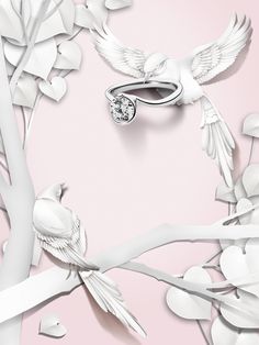 a white bird sitting on top of a tree branch next to a diamond engagement ring