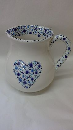 a white pitcher with blue dots in the shape of a heart