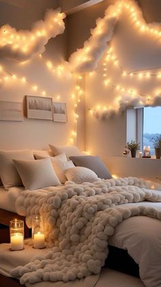 a bedroom decorated in white with lights on the ceiling and clouds hanging from the ceiling