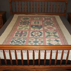 a bed with a wooden headboard and foot board has a quilt on top of it