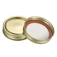 two gold tins with white and red stripe on the lids, one is empty