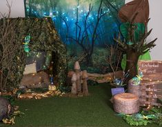 an outdoor display with fake trees and fairy houses in the grass, surrounded by other decorations