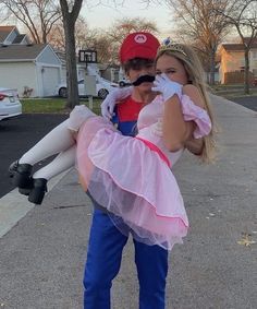 two children dressed up as mario and princess peach, one is holding a stuffed animal